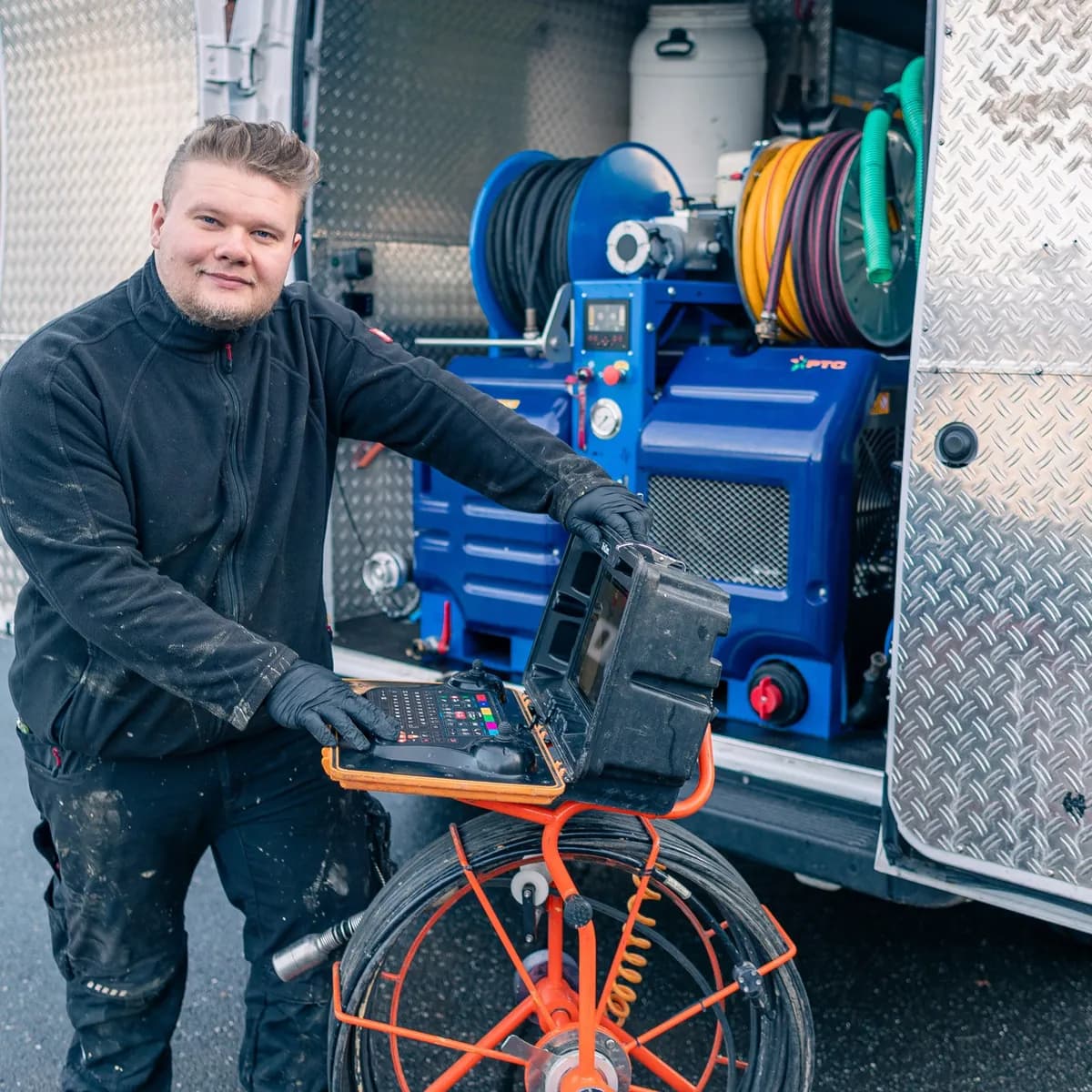 Techniker mit der Kanalkamera vor der Spültechnik im Einsatzfahrzeug
