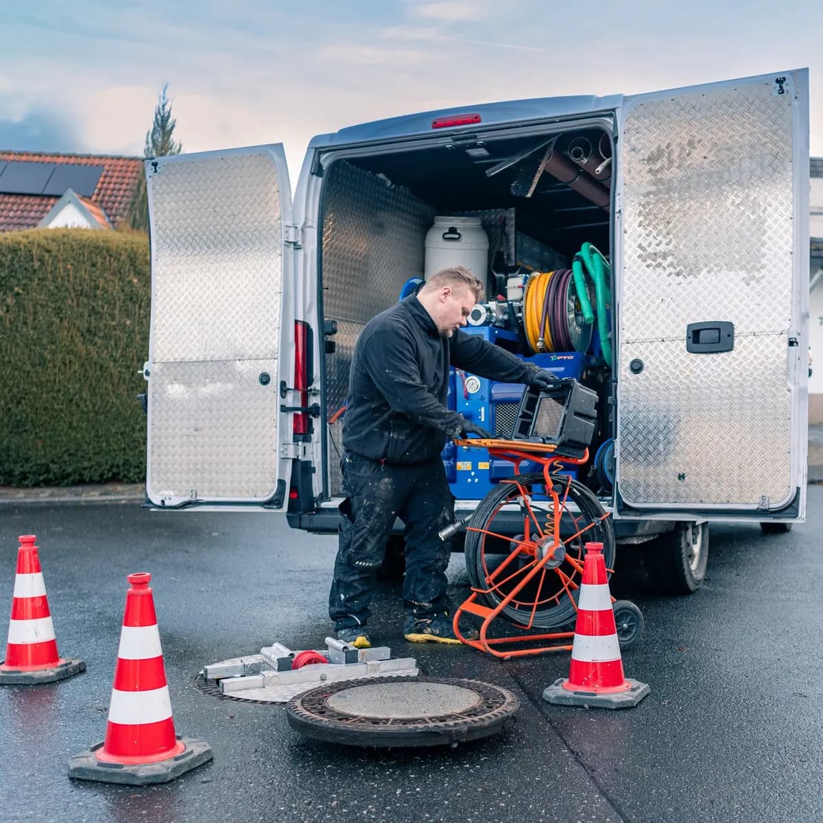 Techniker arbeitet mit Kamerawagen an einem geöffneten Schacht