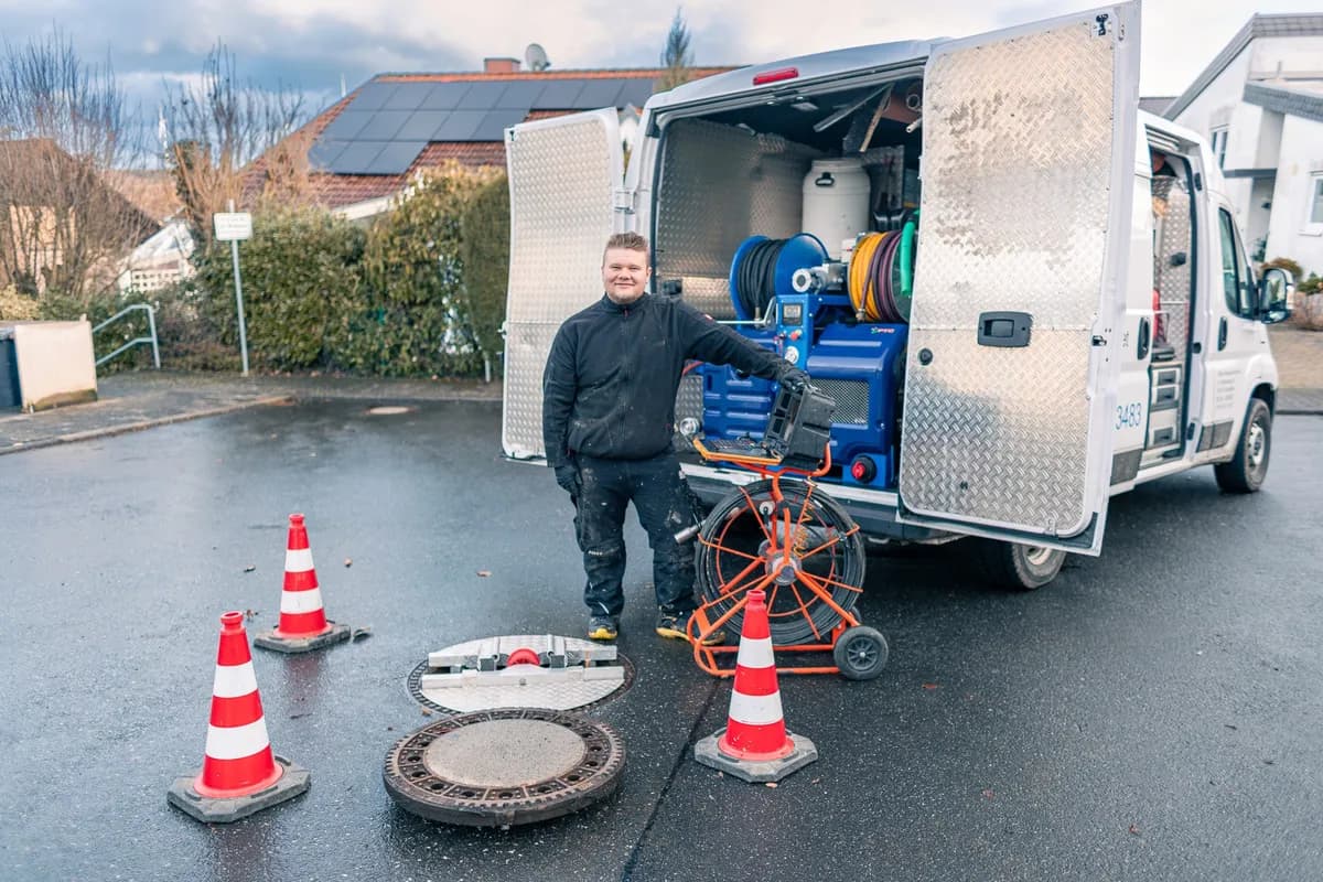 Techniker am Einsatzfahrzeug mit Spül- und Kameratechnik